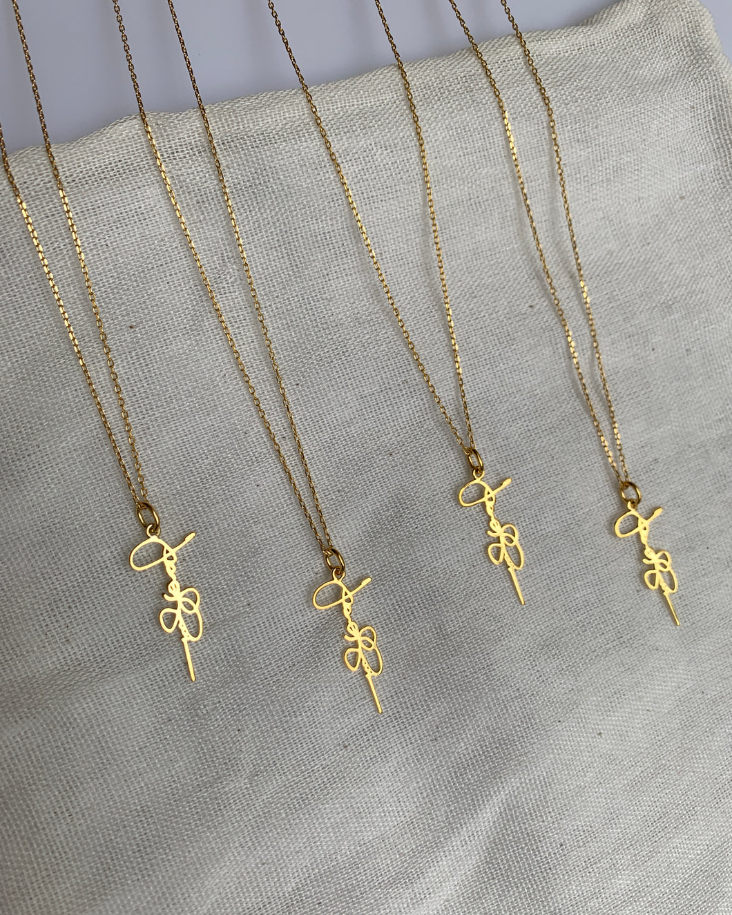 A vertical signature necklace inspired by our client's dad. Set in 14k yellow gold.
